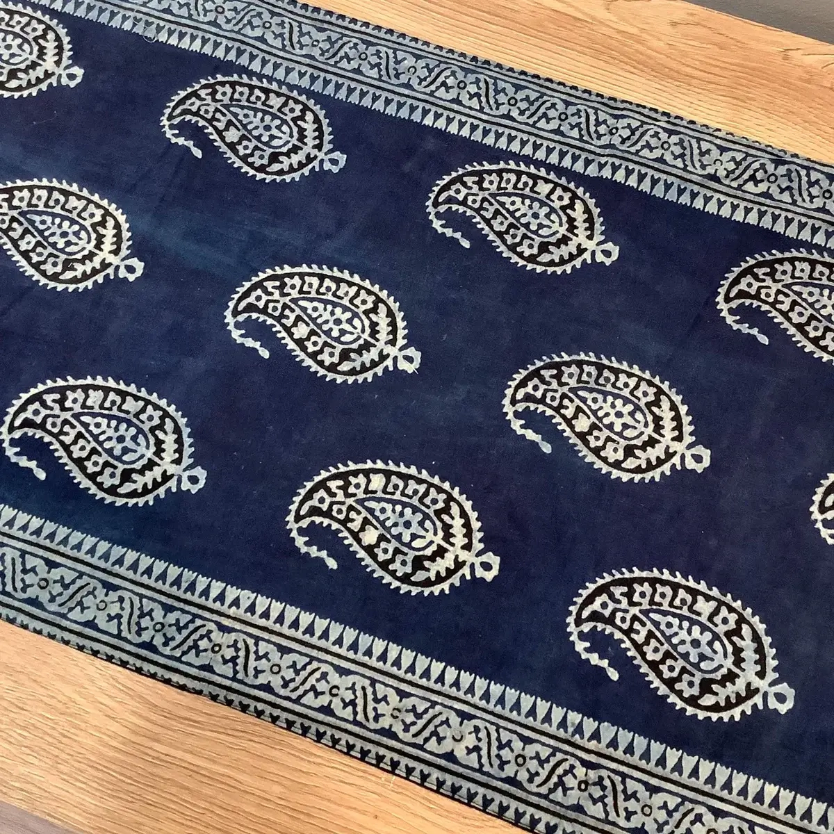 Full view of blue Keri patterned block print table runner with decorative borders and tassels.