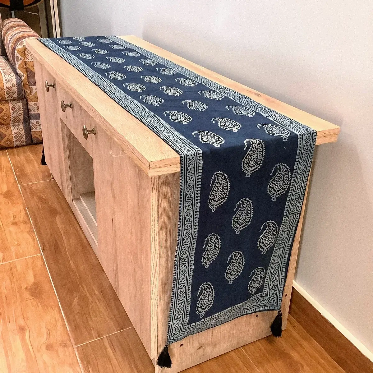 Blue Ajrak block print table runner featuring traditional Keri paisley motifs on a wooden console.
