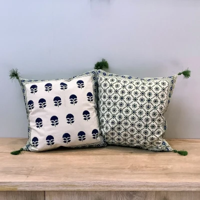Double-sided Ajrak cushion cover featuring blue floral booti motifs on one side and a green geometric floral pattern on the other.