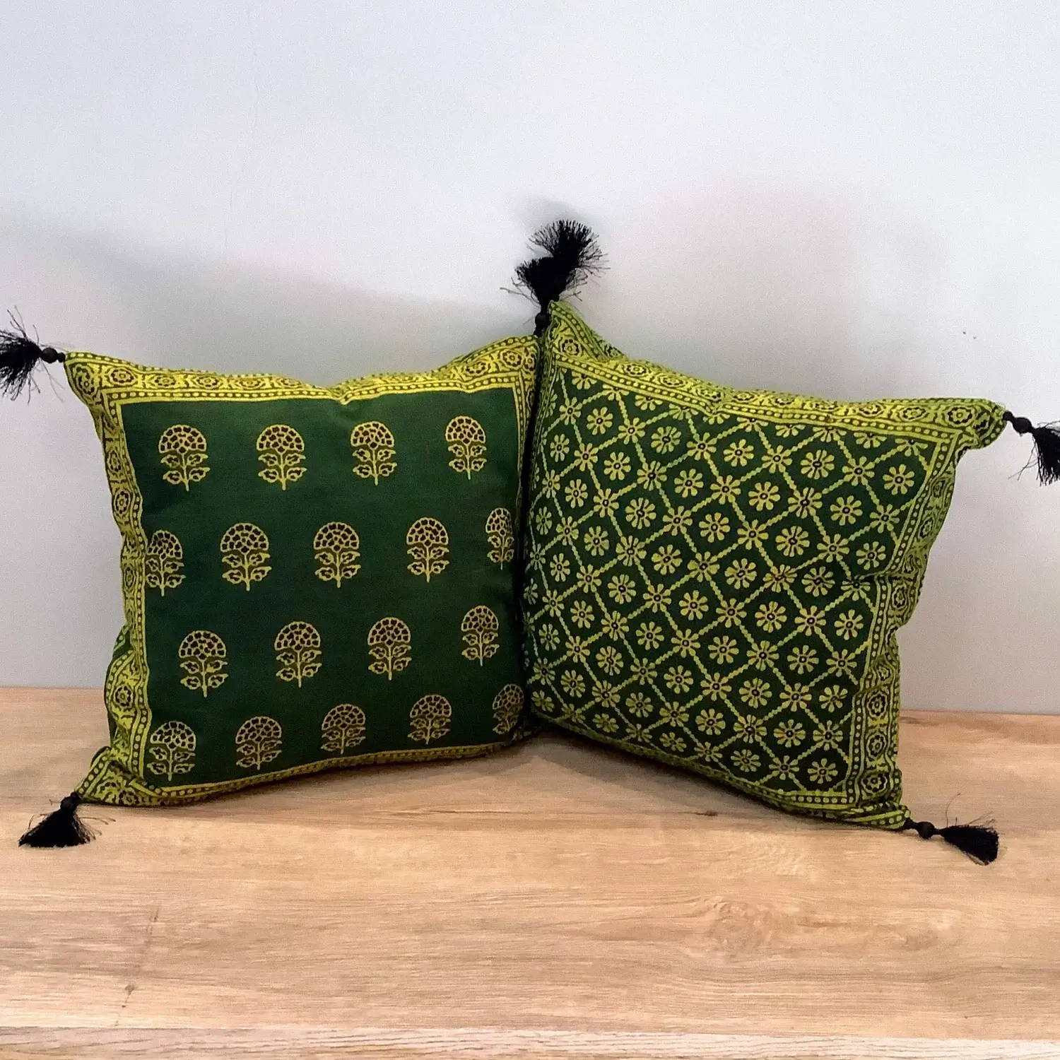 Double-sided Ajrak cushion cover showing floral booti motif on one side and geometric floral pattern on the other.